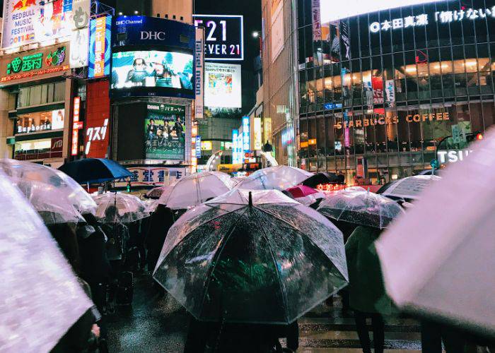 People crossing a road in Tokyo on a rainy day; a sea of umbrellas.